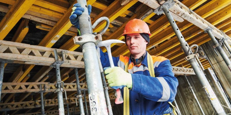 Construction worker erecting scaffolding